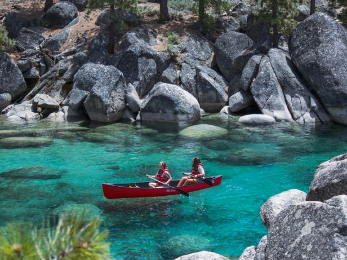 a group of people on a rock in a pool of water
